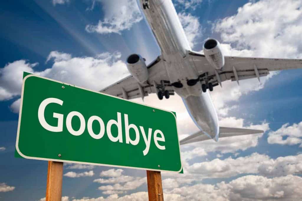 Flugzeug fliegt über ein Schild auf dem Goodbye steht
