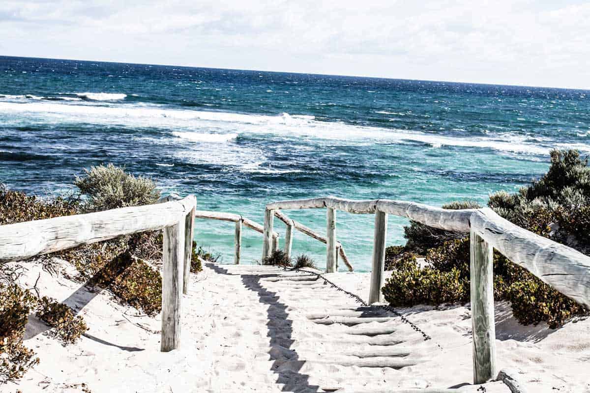 Weg mit weißem Sand führt zum Strand