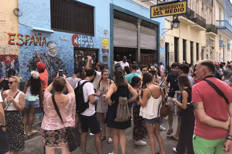 Touristen verewigen sich vor der Heminway Bar La Bodeguita an der Wand