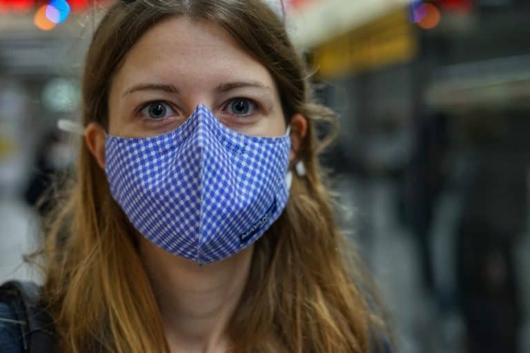 Reisende trägt während Corona Pandemie Gesichtsmaske