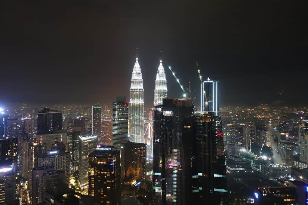 Die Petronas Tower leuchten in der Nacht spektakulär in der Skyline von Kuala Lumpur