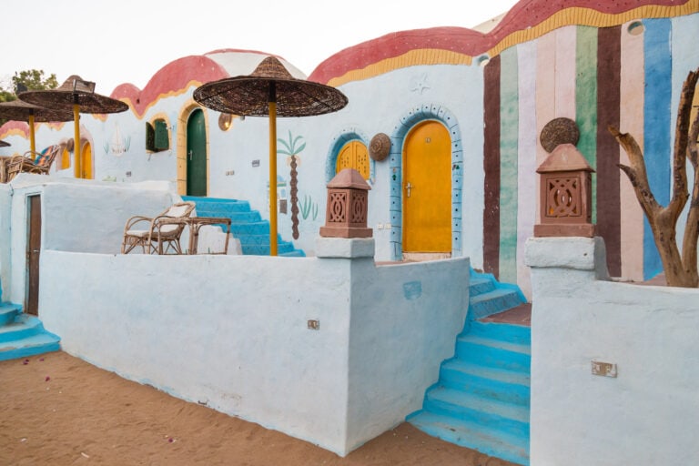 Die farbenfrohen, kuppelförmigen Häuser sind von den Nubischen Dörfern inspiriert und verfügen über blaue Stufen, gelbe Türen und Korbstühle auf einer Sandterrasse.