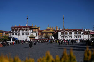 Menschen, die im Innenhof des Jokhang-Tempels in Lhasa, Tibet, spazieren gehen.