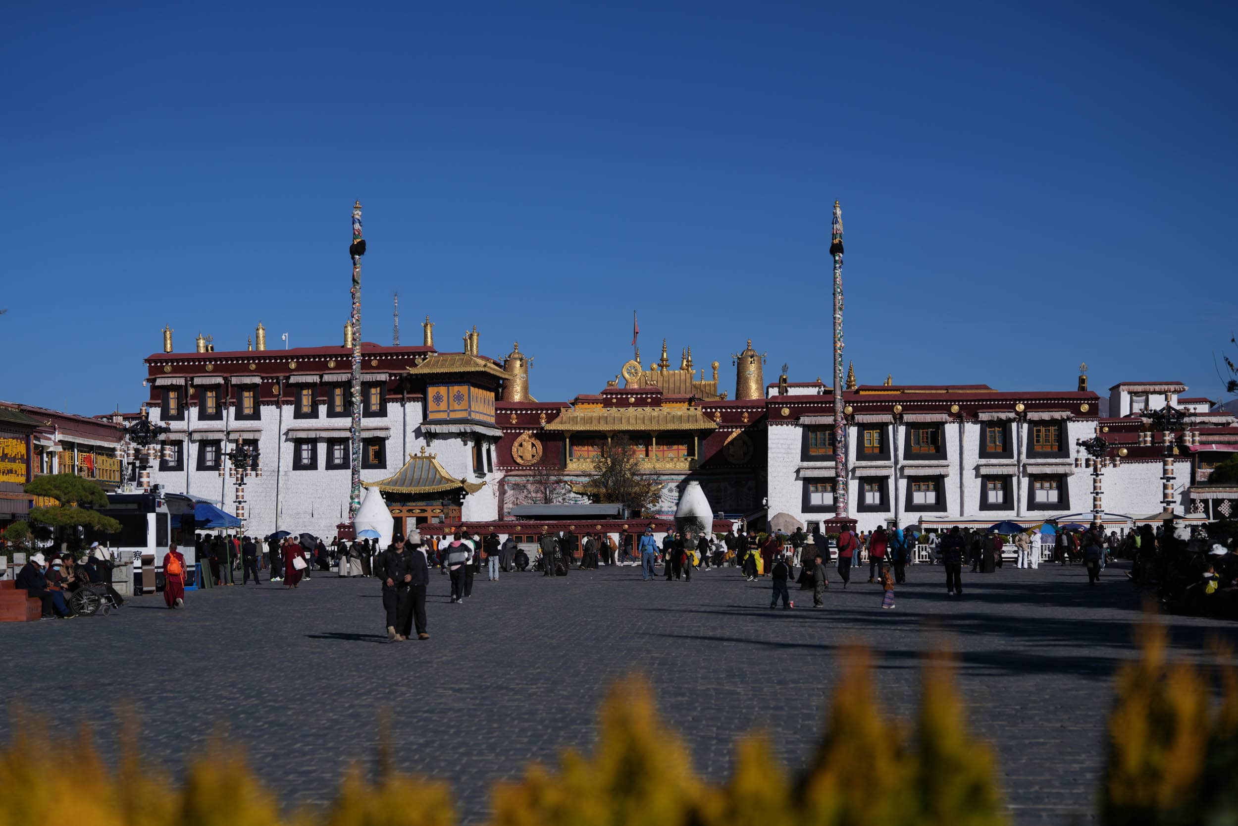 Menschen, die im Innenhof des Jokhang-Tempels in Lhasa, Tibet, spazieren gehen.