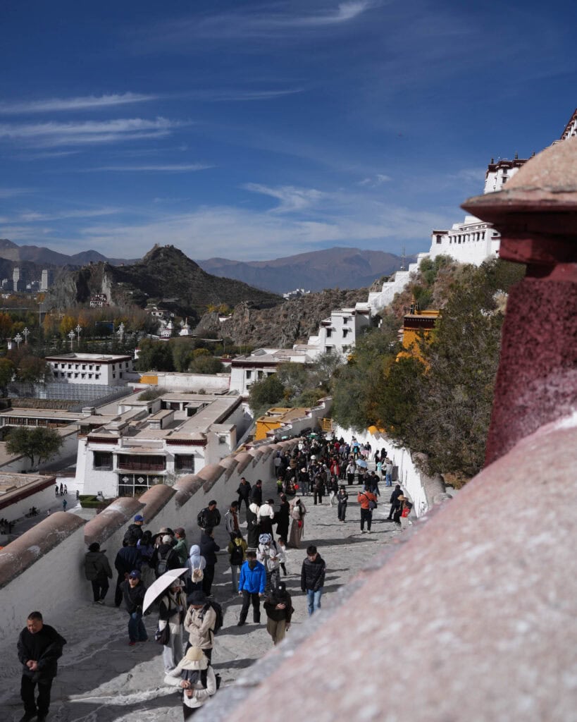 Touristen, die einen steilen Weg hinauf zum Potala-Palast gehen.