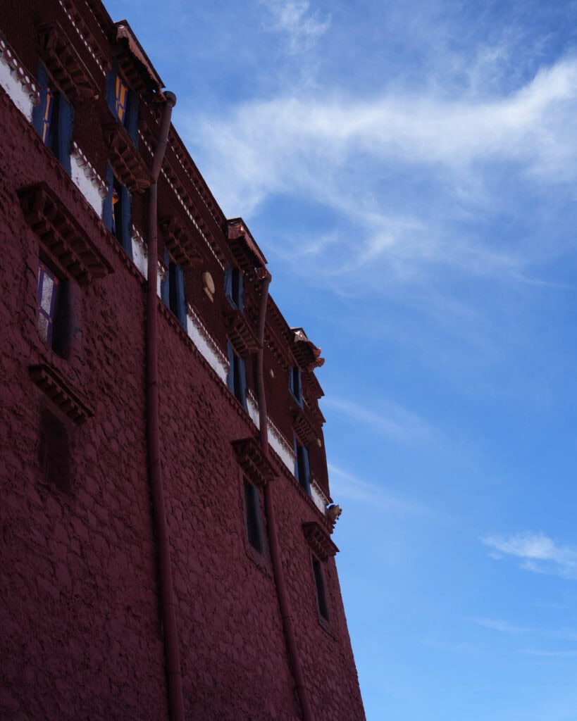 Die rote Mauer des Potala-Palasts vor blauem Himmel.